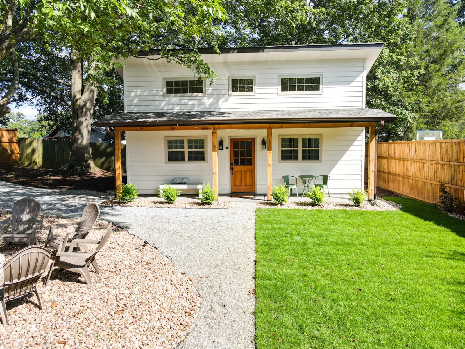 Exterior of the two-story Cozy Cottage with covered porch and gravel path
