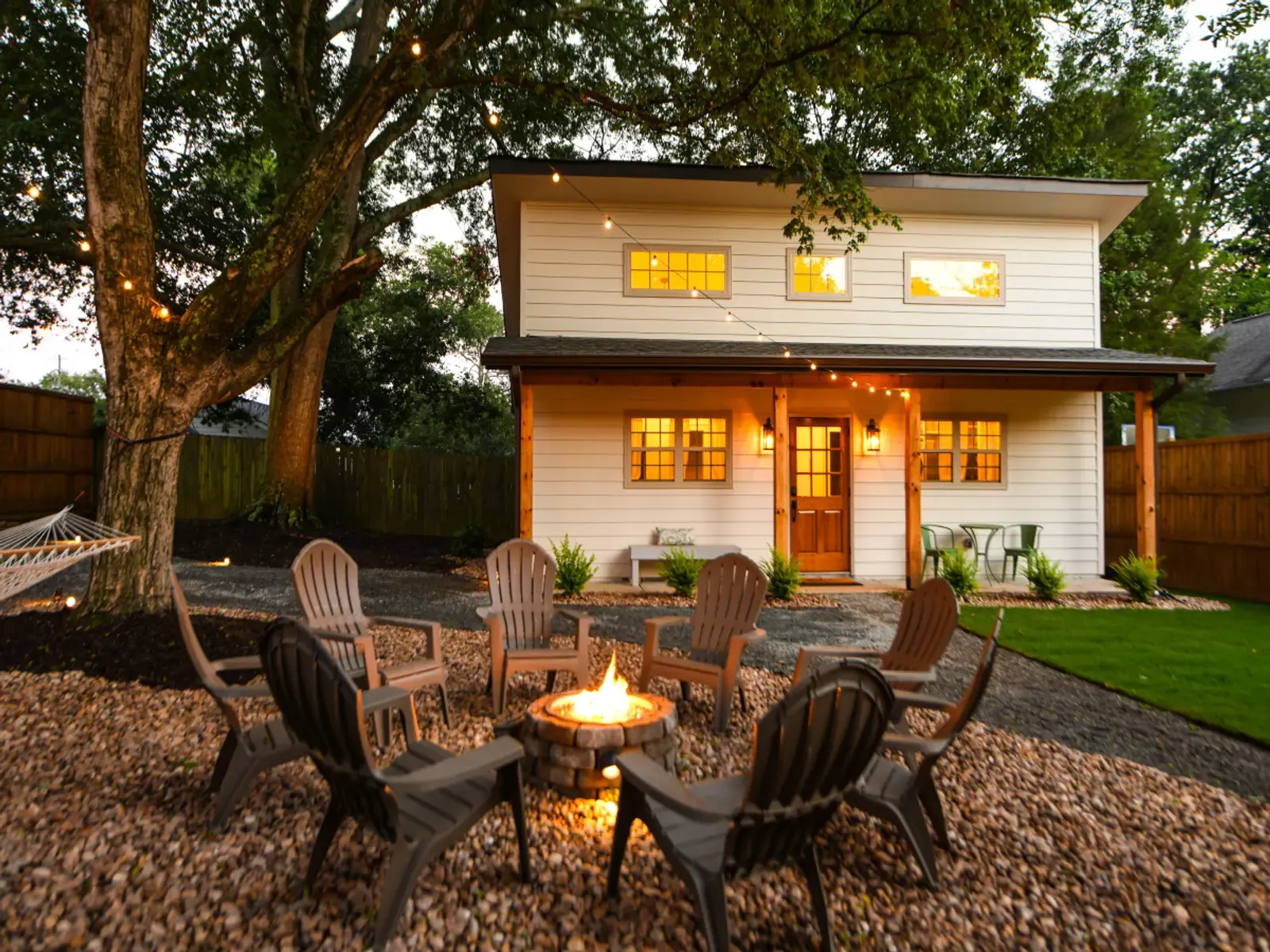 Cozy Cottage at dusk with the fire pit lit in the shared yard