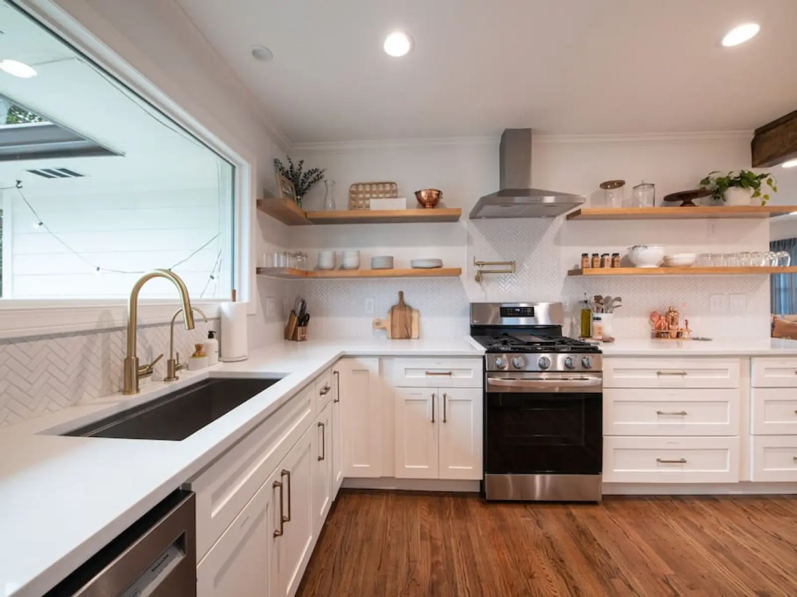 Crossing House chef's kitchen with gas range, open shelving and farmhouse sink