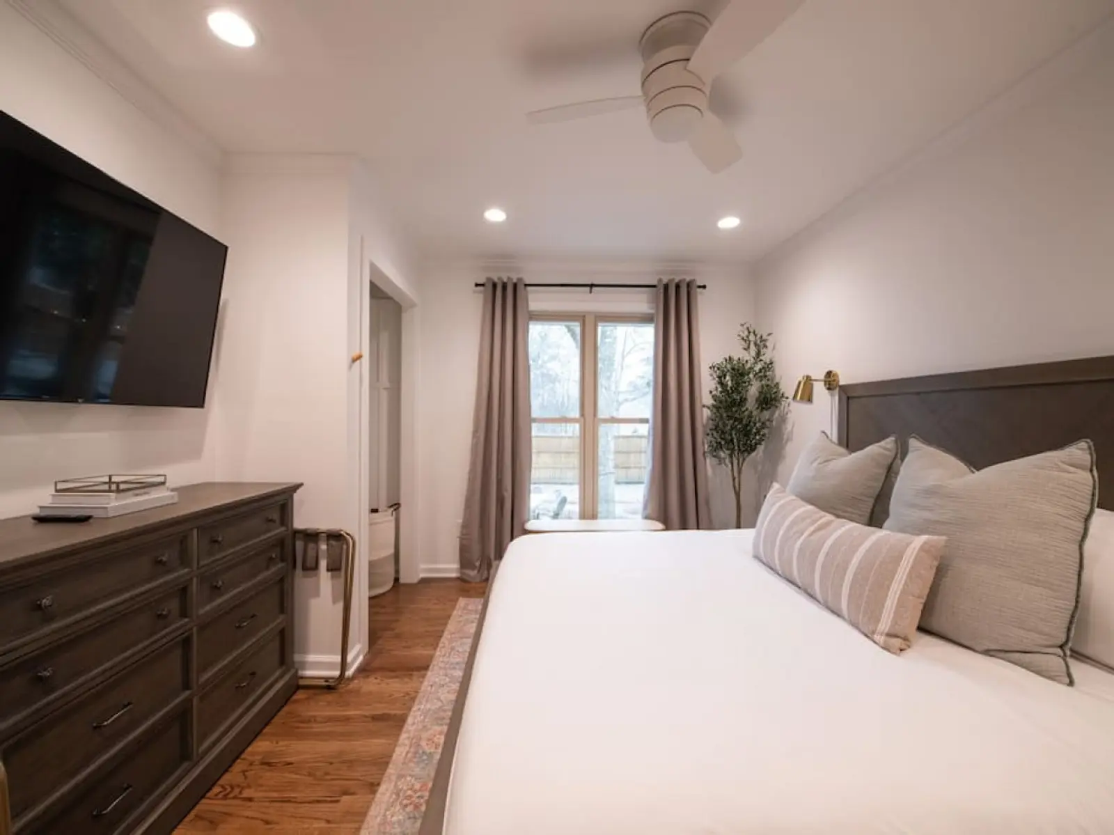 Crossing House king bedroom with French doors and a wall-mounted TV